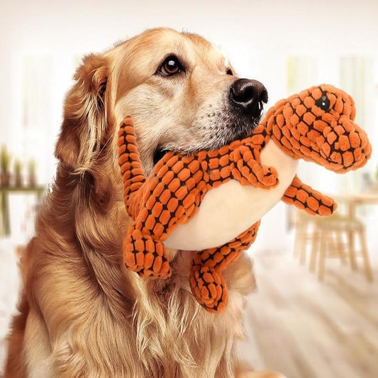 Golden retriever holding a plush dinosaur toy from Magic Pet Products, designed for interactive play and durability.